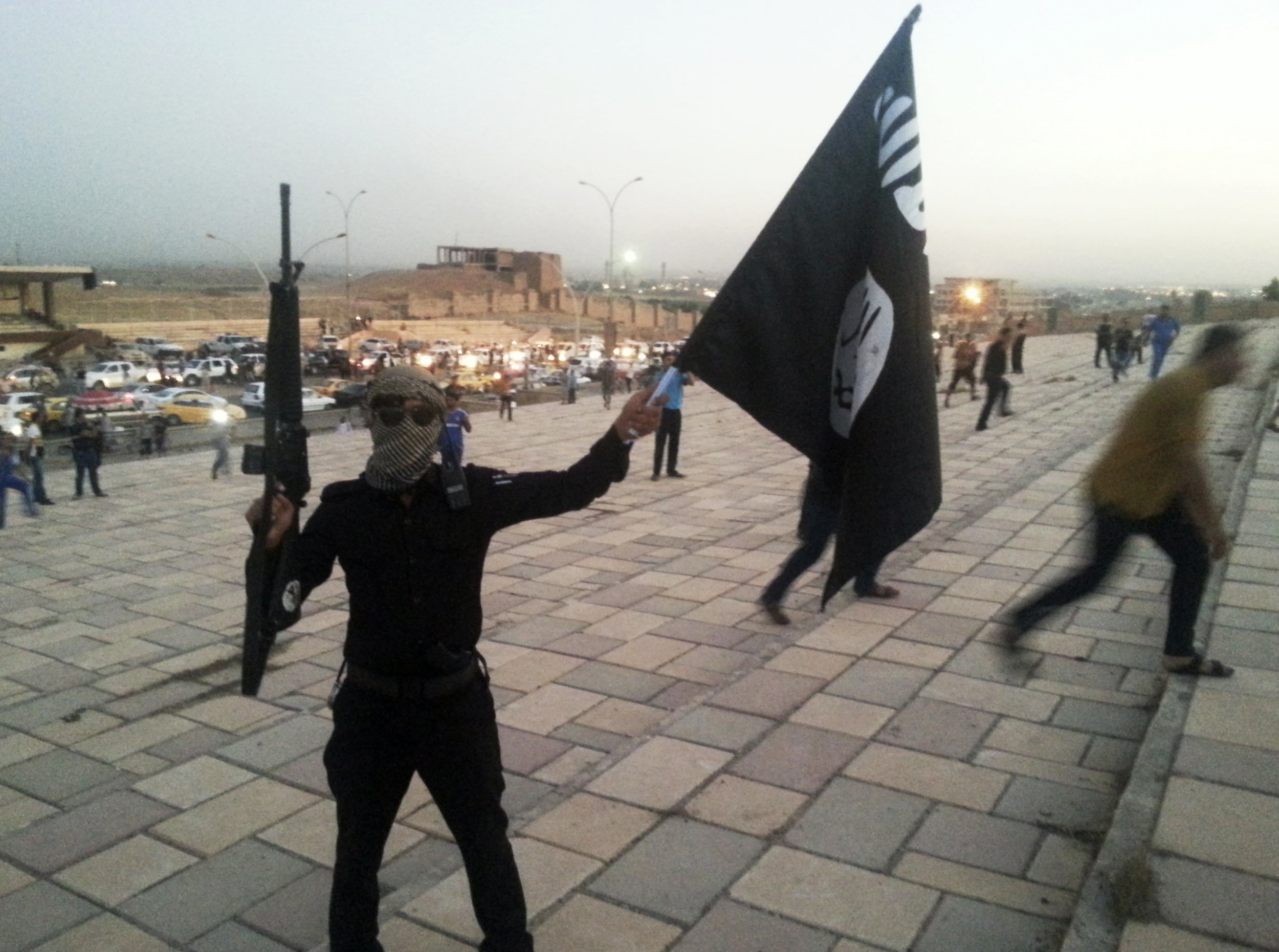 An Islamic State fighter waves the group's flag