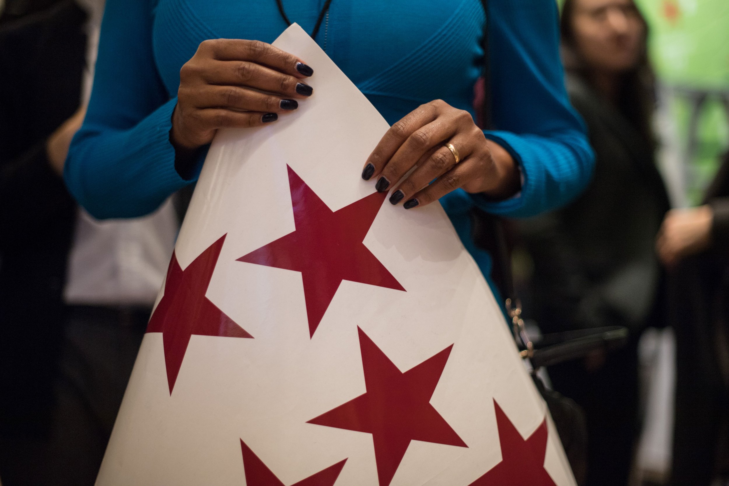 A woman holds a sheet of sticky red stars