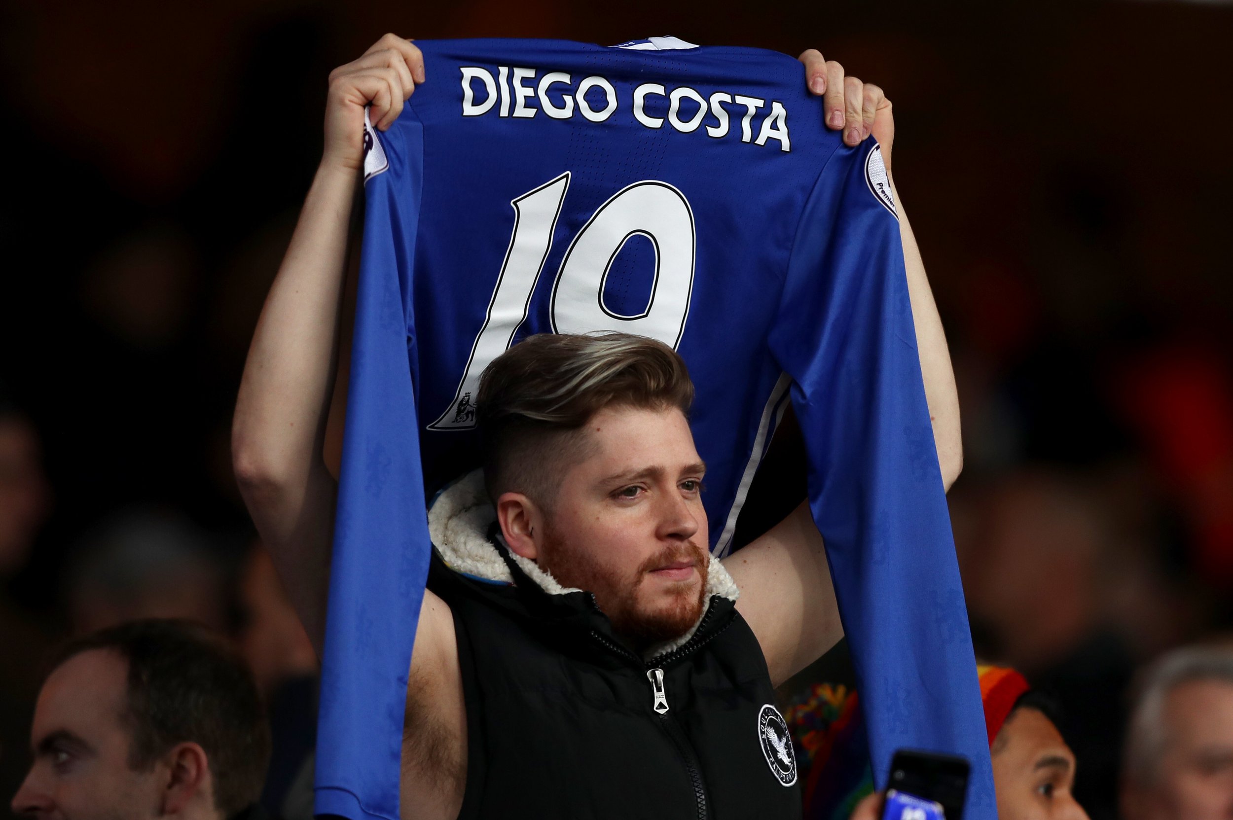 A Chelsea fan holds up a Diego Costa shirt