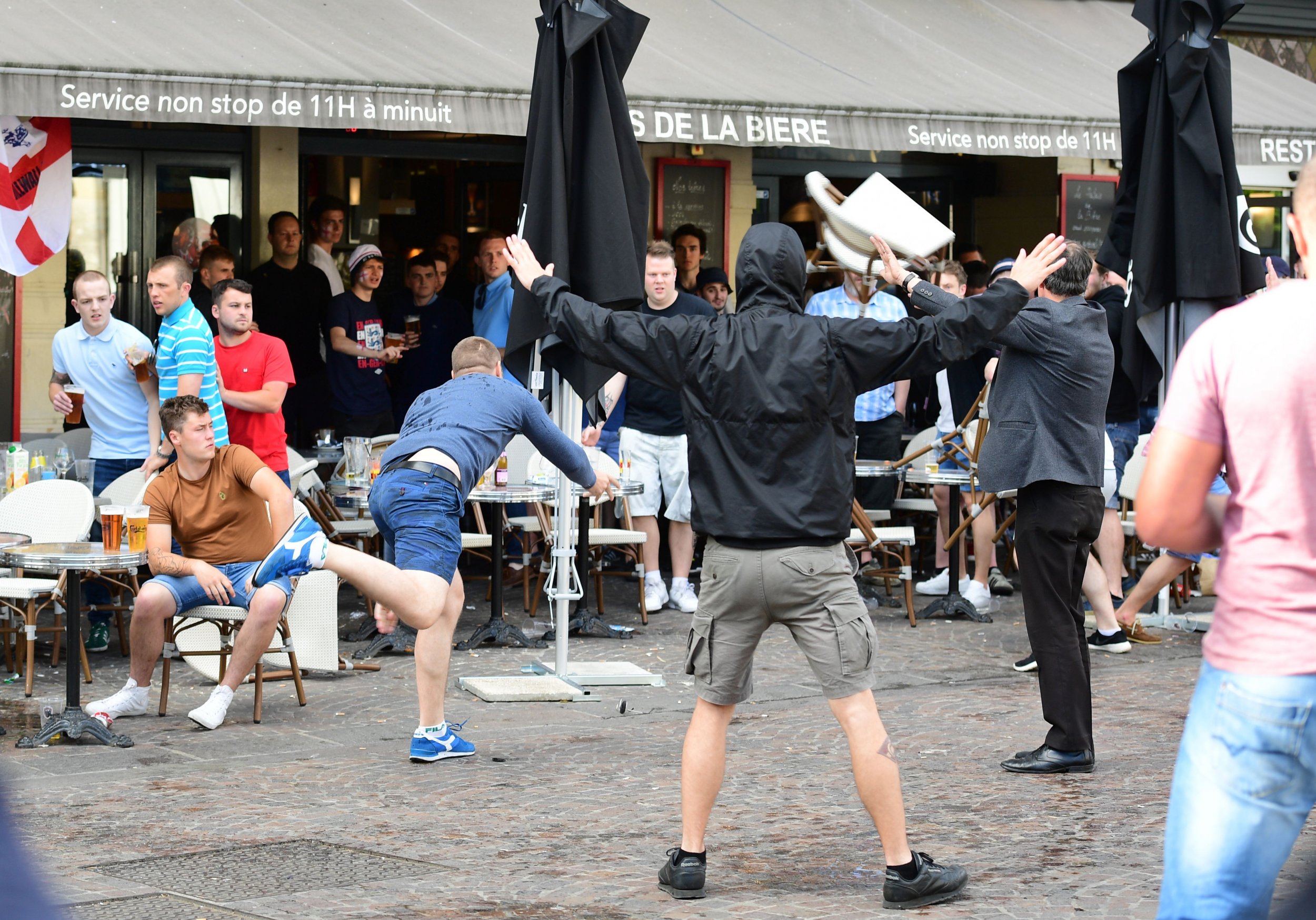 A Russia football supporter lobs a chair towards England fans sitting in a cafe in the northern city of Lille on June 14, 2016..