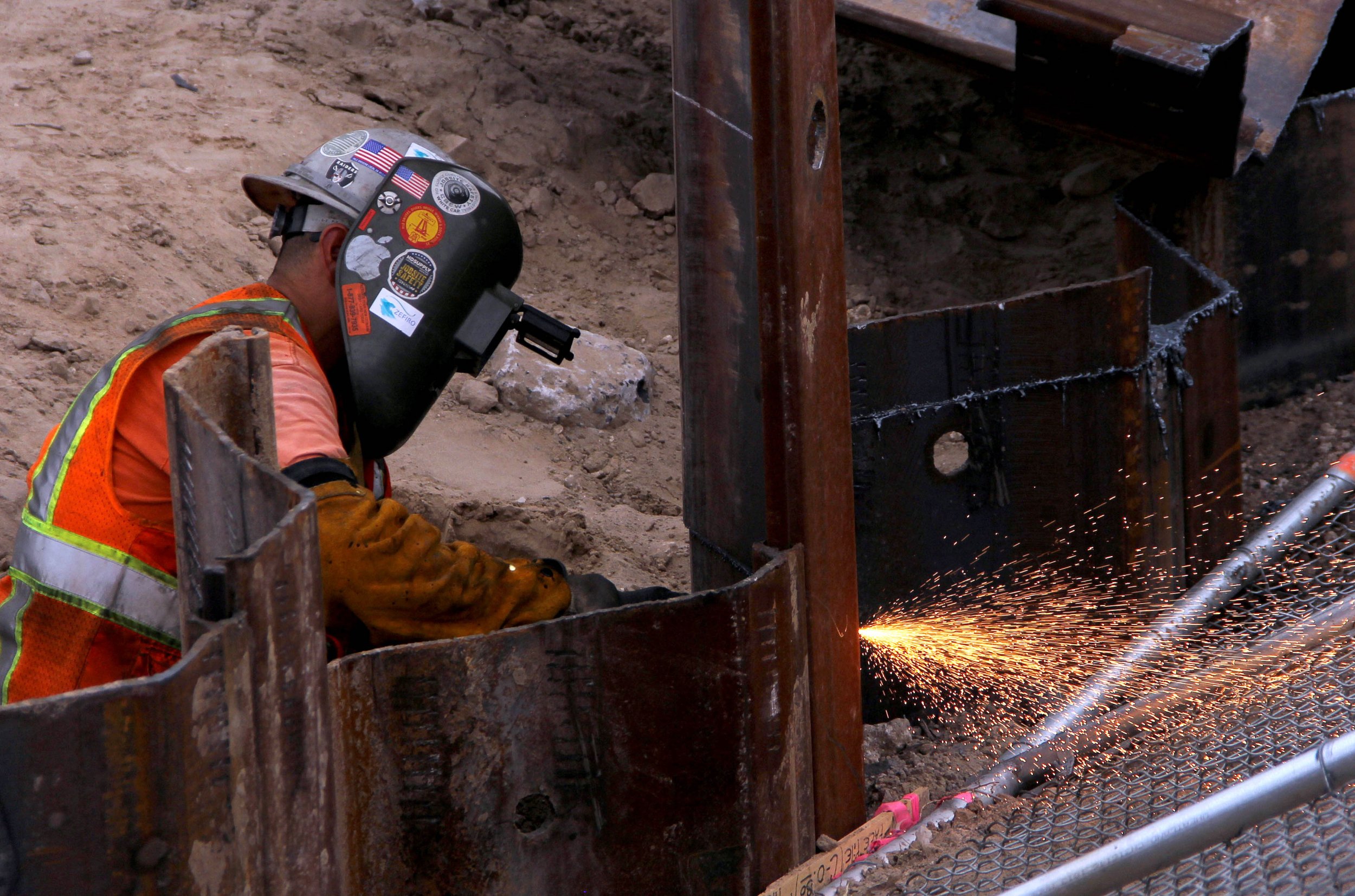 A man welds the Mexico-US border wall