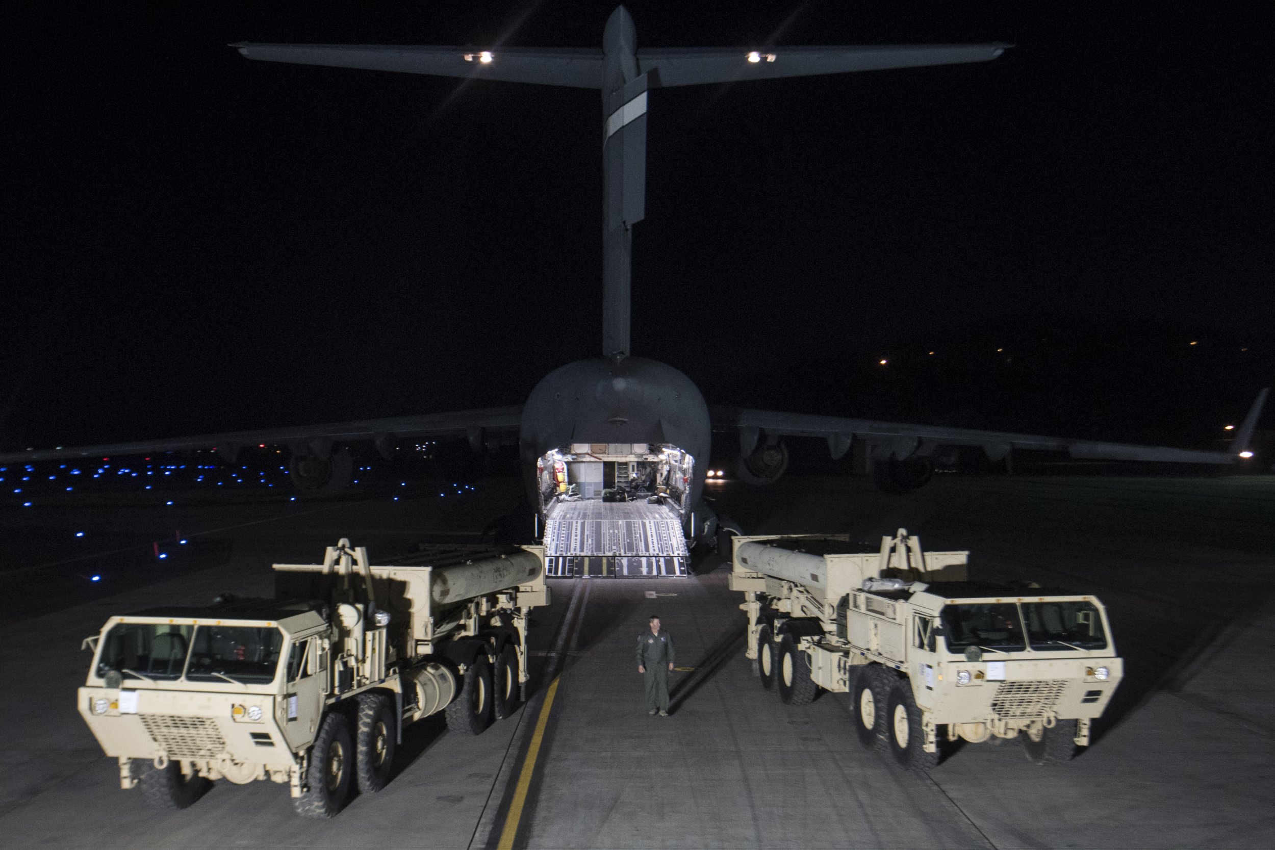 U.S. military trucks by a plane