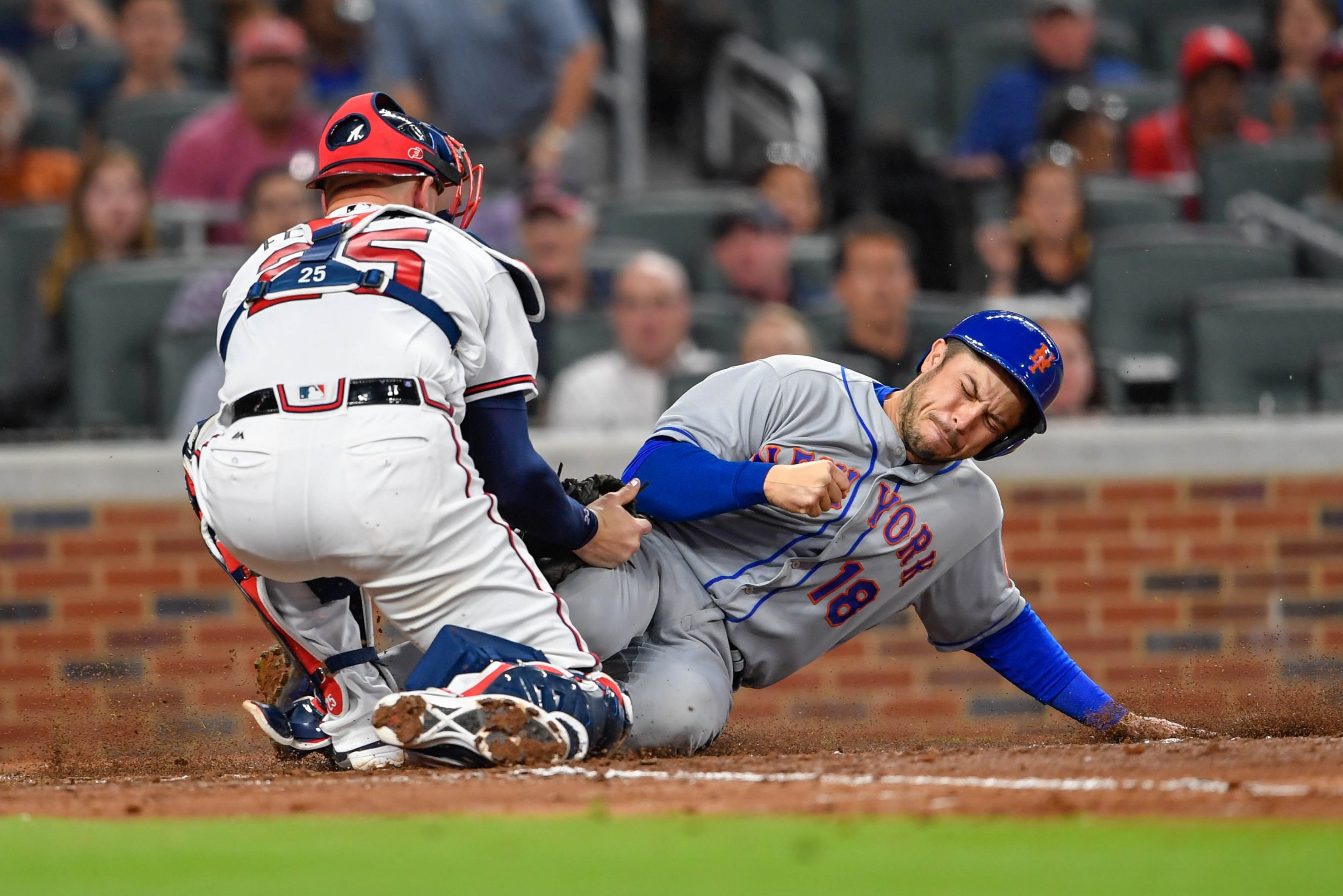 New York Mets catcher Travis d'Arnaud, right, slides under the tag by Atlanta Braves catcher Tyler Flowers at SunTrust Park, Atlanta, May 1 2017.