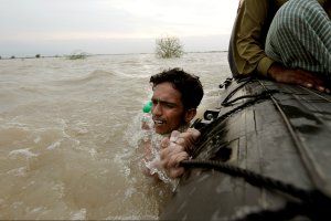 asia-fire-floods-pakistan-man-boat