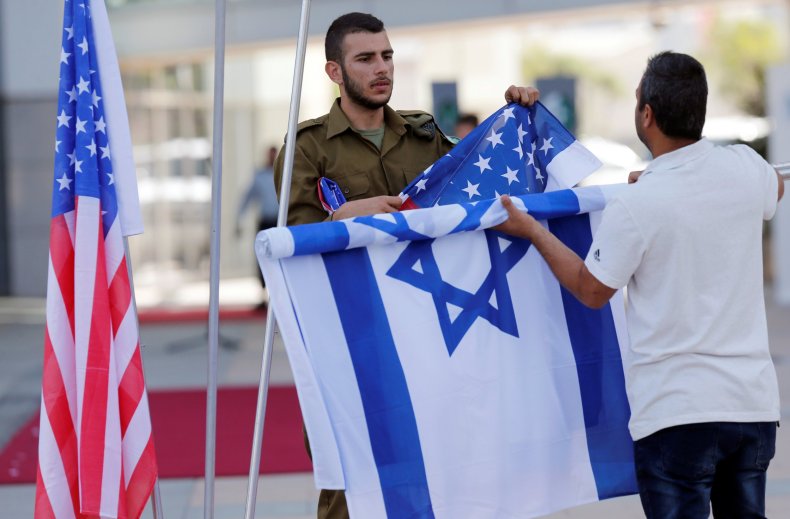 An Israeli soldier rolls up the flag of Israel