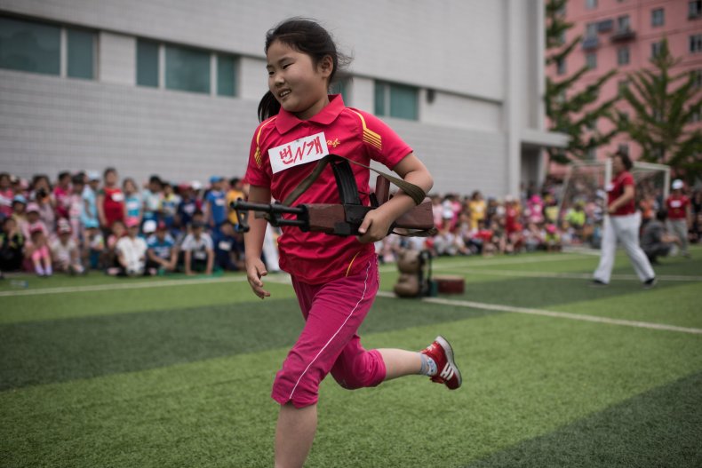 North Korean child carrying mock rifle